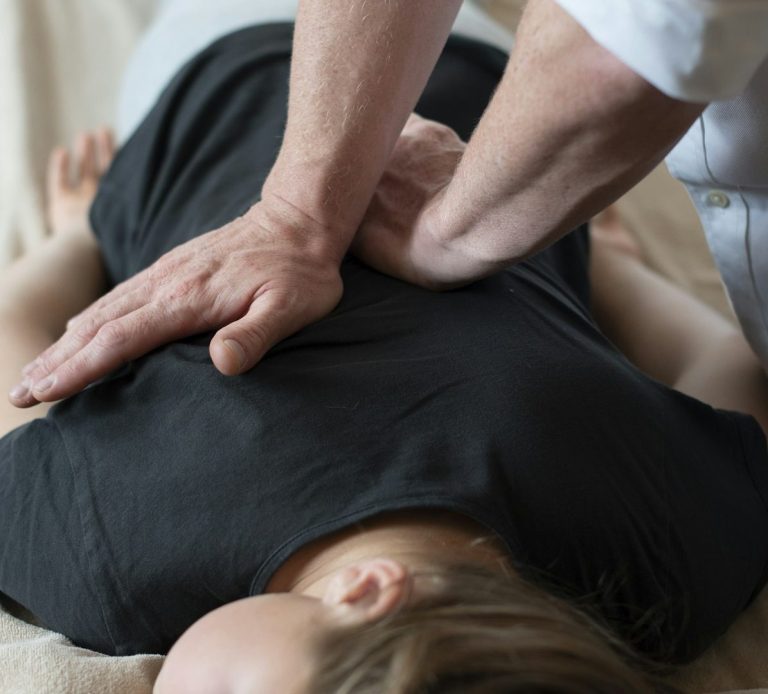 Osteopath assessing a patient